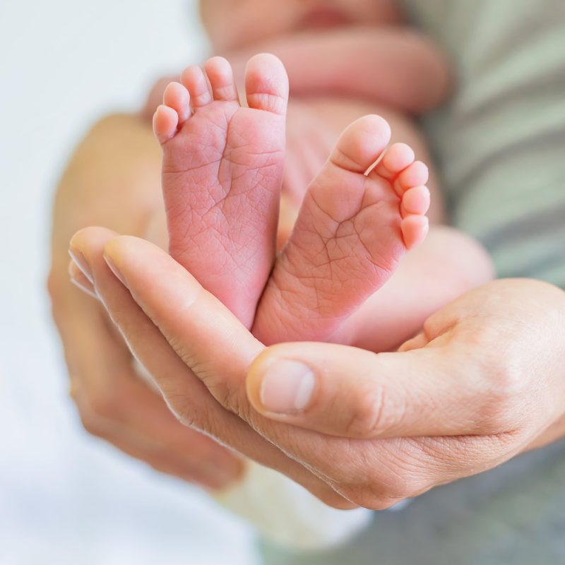 newborn-baby-hands-father-selective-focus-people